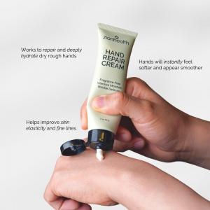 A close-up of a person applying Zion Health Hand Repair Cream from a light green tube onto their hand, with text highlighting its ability to repair, hydrate, and improve skin elasticity.