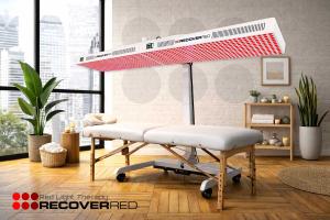 A full body red light system over a white massage table in a peaceful room.