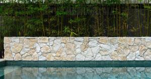 Natural stone feature wall behind mosaic tiled plunge pool in Seaforth Northern Beaches Sydney.