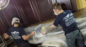 Repipe Solutions Inc technicians protecting kitchen cabinets during whole house repiping project in New Caney TX home