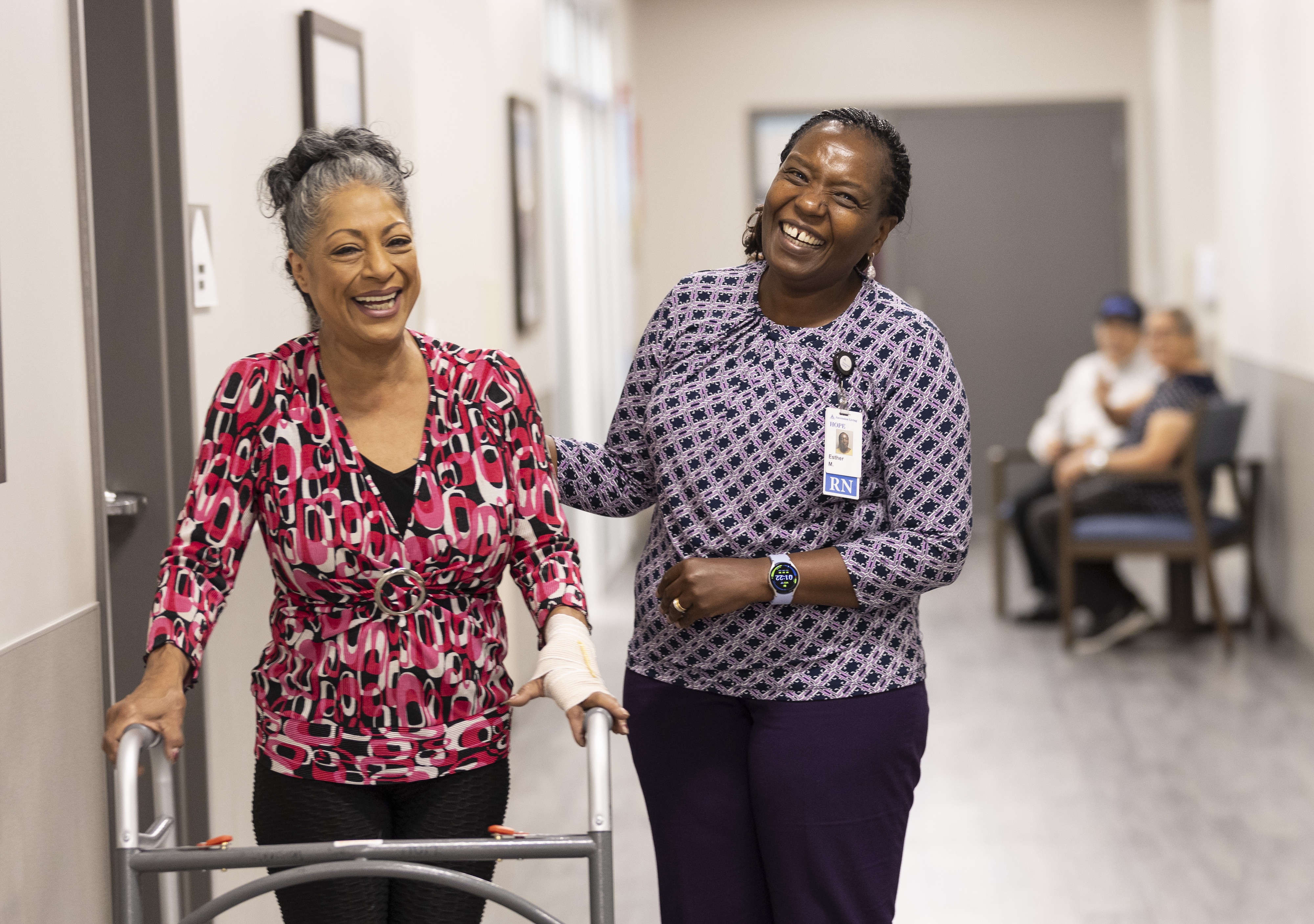 A woman using a walker and her nurse