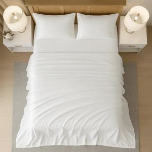 Top view of a neatly made bed with smooth white sheets and two white pillows, flanked by matching bedside tables with lamps in a modern, minimalist bedroom.