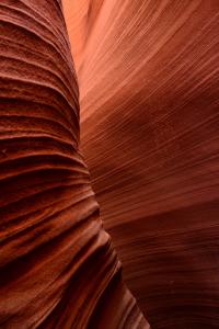 Close-up view of Antelope Canyon sandstone walls showing smooth, flowing red rock lines formed by erosion.