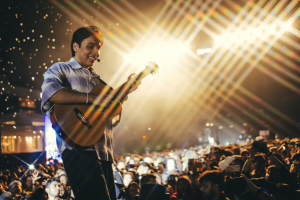 Anuv Jain on stage holding a guitar in front of a packed crowd during the Dastakhat World Tour 2026. Anuv Jain is coming to North America as his next stop.