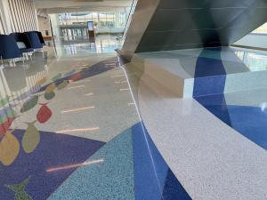 swimming fish and terrazzo colors continue through a plinth beneath a staircase