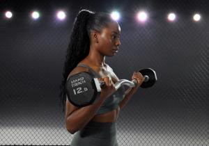 Female athlete lifts a fixed weight barbell.