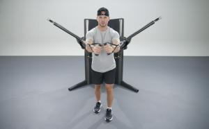 Male athlete uses a dual-access pulley strength machine.
