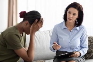 photo of a professional counseling in a session with a client who appears to be in a state of emotional distress