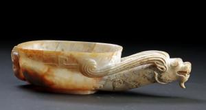 Far East, China museum-exhibited, carved jade cup of elongated form, from the Warring States period, circa 475-to-221 BCE; a shallow, oval vessel worked from pale white jade. Estimate: $30,000-$45,000