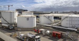 Airport fuel storage tanks and jet fuel tanker truck at an aviation fuel depot, representing upstream SAF supply chain infrastructure.