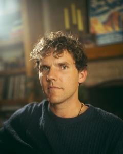 Phoenix singer-songwriter Joey Gutos in a warmly lit portrait promoting his indie rock single “It Just Feels Right.”