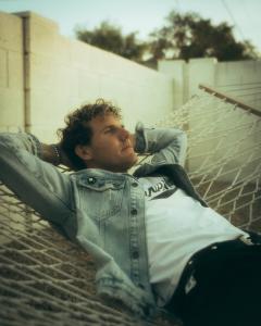 Joey Gutos reclining in a hammock at sunset while promoting his indie rock single “It Just Feels Right.”