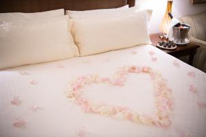 Heart-shaped rose petals on the bed