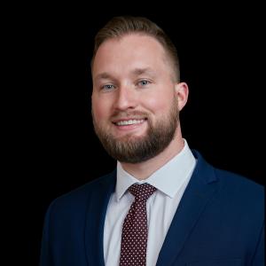 Tyler Junell, COO of Job-Dox, smiling in a professional headshot photo."