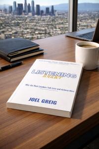 Listening Louder book placed on an office desk of a leader overlooking the city.