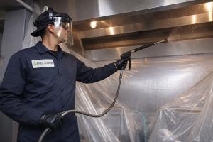 A commercial hood cleaning expert from filta kleen cleaning a restaurant hood