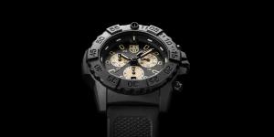 Luminox Navy SEAL Chronograph 3580 Series black tactical dive watch with black carbon case, unidirectional bezel and sand chronograph subdials on black rubber strap against black background