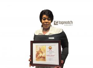 Cardine Johnson of TopNotch Resort holding UMF|PerfectCLEAN Hospitality Hygiene Specialist Excellence Award