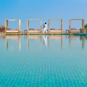 Poolside view with reflections of waiter bringing a sheesha to a cabana in the Maldives