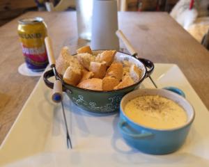 Traditional Swiss cheese fondue with fresh bread served at Cuckoo Clock Brauhaus in Miami, paired with imported European beer.