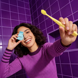 Smiling girl with yellow toothbrush and expanding floss