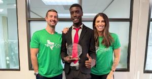 A smiling Third Coast Events professional in a suit holding a crystal trophy alongside team members in branded green t-shirts.