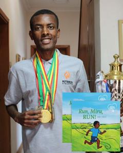 A photo of Miru with his medals and a trophy from an international race.