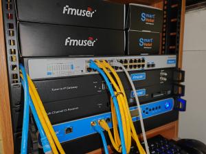Real deployment of FMUSER hotel IPTV system headend equipment and CAT6 network switches in a server room