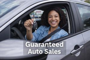 Happy customer holding new car keys in the driver’s seat at Guaranteed Auto Sales in Johnston, Rhode Island.