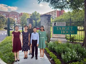 Five young EAMA piano students in formal attire standing in front of the Target House sign at St. Jude Children's Research Hospital in Memphis, Tennessee.