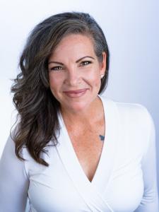 Dr. Jones expresses competence stands in a white top with a white background.