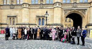 Large group of 40+ delegates posing outside the Gothic arched entrance of the Palace of Westminster after the Impact and Sustainability Summit.
