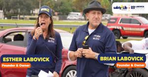 Esther and Brian LaBovick speaking in front of staged crash scene during Safety 4 Life teen driving reenactment in West Palm Beach.