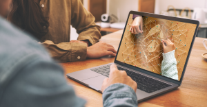 Two people reviewing campaign planning visuals on a laptop, representing Concept to Comic™ Stage 2 IP Incubation and crowdfunding launch preparation.