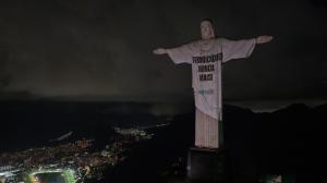 Christ the Redeemer Sanctuary in Rio de Janeiro, with the monument illuminated to say NO MORE in solidarity with survivors of violence and Brazil's commitment to cultural change