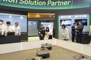 Visitors observing robots by Hyundai Movex at its booth
