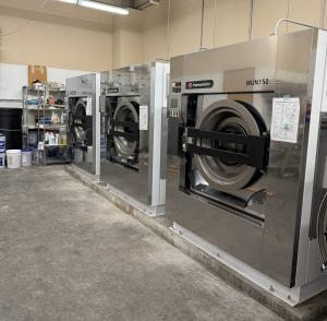 Three WUN150 washer/extractors installed by the Walter E. Nelson team at Silver Reef Casino in Ferndale, Washington, positioned side by side in the commercial laundry facility.