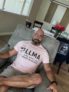Man in shirt with LLMA logo sitting in chair