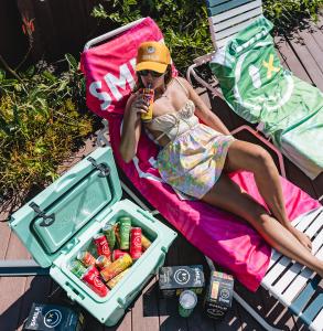 Smile Spirits vodka-based ready-to-drink cocktails in a cooler during a beach and outdoor lifestyle setting
