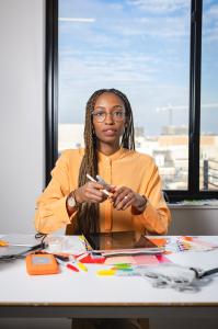 Creative professional, Nile Livingston, Founder and CEO of Creative Repute, reviewing design materials and digital tools at a workspace, representing structured collaboration and creative strategy.