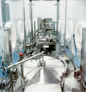 Interior view of BioTechnique’s Flexicon filling system within an aseptic isolator, displaying conveyor tracks, filling modules, and glove‑port access.