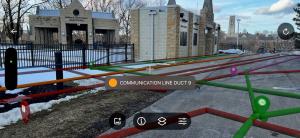 A photo outside on the University of Toledo campus, showing the colored and labeled utility lines running underground as visualized with the new SiteMap 3.0 Augmented Reality feature.