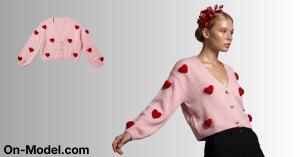 A model wearing a pink heart-patterned cardigan with a floral headpiece, posing against a neutral background.