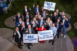 Cornerstone International Alliance partner celebrating 2025 results, holding signs reading "$2.5 Billion in Companies Sold," "382 Deals Closed," and "We are Stronger Together."