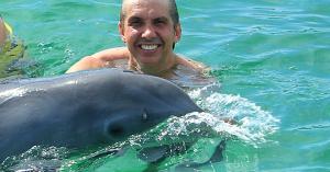 John the Dolphin Expert swimming with a dolphin at Dolphin Island Punta Cana in natural Caribbean seawater.