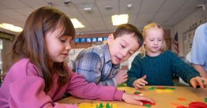 Elementary students explore mathematical ideas using hands-on manipulatives during a classroom learning activity.