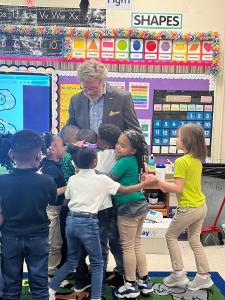 Mayor Gibson receiving hugs from the students during a visit to read to the schoolchildren.