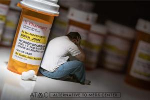 Man sitting distressed beside prescription pill bottles symbolizing concerns about psychiatric medication dependence and the need for supervised tapering.