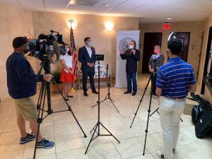 Hadi Suheil filming media coverage of a press conference during the COVID-19 pandemic