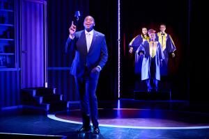 The actor who plays Obama in 44: The Musical singing on stage with a choir